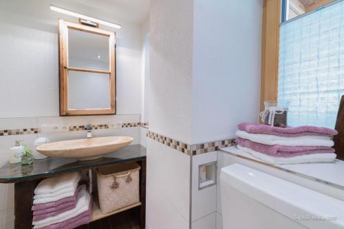 a bathroom with a sink and a mirror and towels at Apartment Gehrenspitze in Reutte