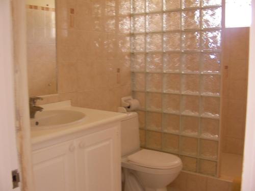 a bathroom with a toilet and a sink at Plover Court Apartments in Christ Church