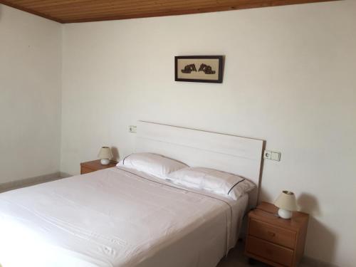 サン・フランセスク・ハヴィエルにあるSa Figueraのベッドルーム1室(白いベッド1台、ナイトスタンド2台付)