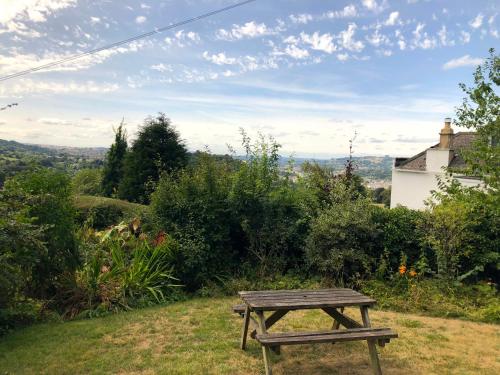a wooden picnic table sitting on top of a field at Spacious home in Bath, nature and city! in Bath