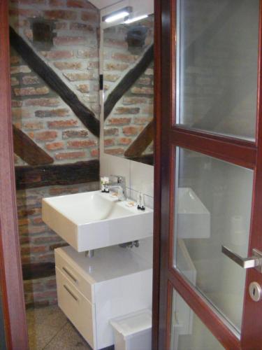 a bathroom with a sink and a brick wall at Amosa Liège City Centre Apart Gerardrie 23 in Liège