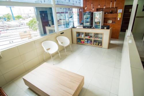 a restaurant with two white chairs and a counter at Pousada Maanaim in Campina Grande