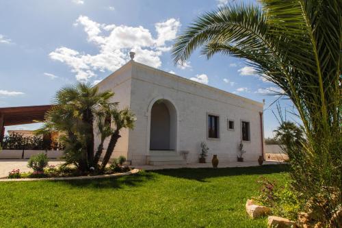 a small white church with palm trees in the yard at Rifugio Delle Grotte in Castellana Grotte