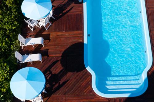 an overhead view of a swimming pool next to chairs and a table at Favorita Golden Hotel e Eventos in São José