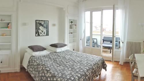 Un dormitorio con una cama con almohadas. en Appartement avec vue panoramique en Vichy