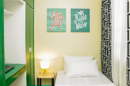 a bedroom with two posters on the wall and a bed at Nomads MNL Backpackers Homestay - near Airport in Manila