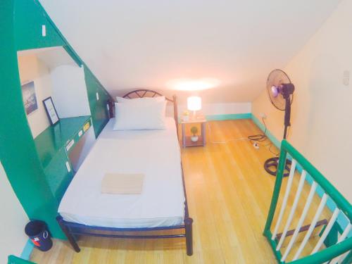 a small room with a bed and a staircase at Nomads MNL Backpackers Homestay - near Airport in Manila