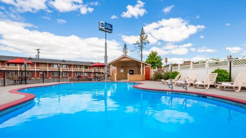 a swimming pool with chairs and a hotel at Best Western Garden Villa Inn in Roseburg