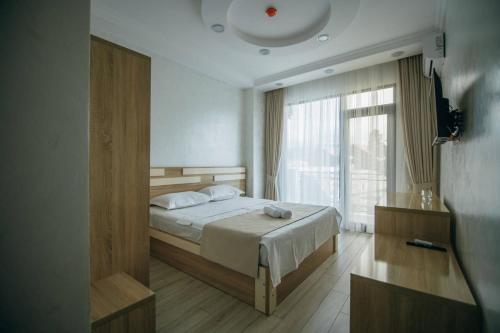 a bedroom with a bed and a large window at Hotel Batumi Palace in Batumi