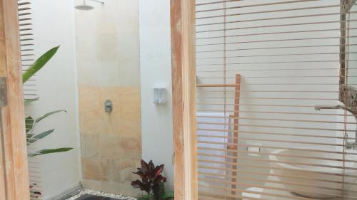 W łazience znajduje się prysznic ze szklanymi drzwiami. w obiekcie Villa Ummangur 2 BR Private Villa Near Lovina w mieście Banjar