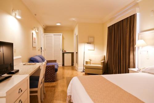 a hotel room with a bed and a television at Vitória Hotel Convention Indaiatuba in Indaiatuba