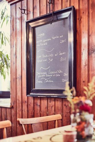 a chalkboard with a menu on a wooden wall at Zur Glashütte Landpension in Fabrikschleichach