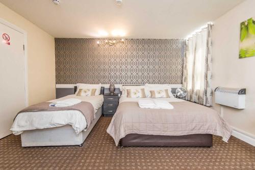 um quarto com 2 camas e uma janela em Bradford serviced apartments em Bradford