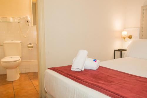 a hotel room with a bed and a toilet at Hostal Callejon del Agua in Seville