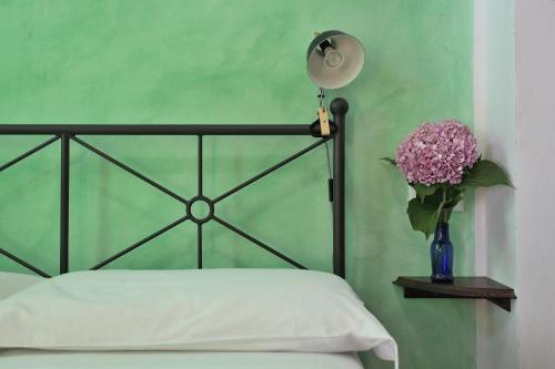 a bed with a lamp and a vase of flowers at Ca' De Angiolina in Sanremo