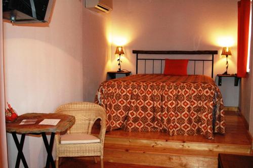 マルヴァオンにあるQuinta Do Vaqueirinho - Agro-Turismoのベッドルーム1室(ベッド1台、テーブル、椅子付)