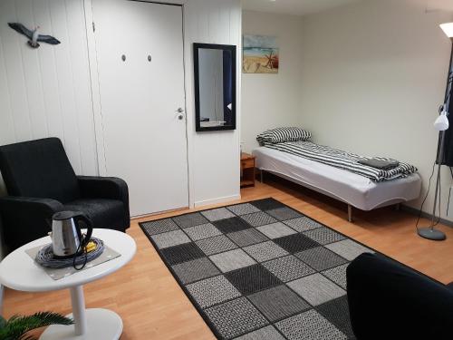 Sala de estar con cama y mesa en Wilhelmsen Romutleie, en Vardø