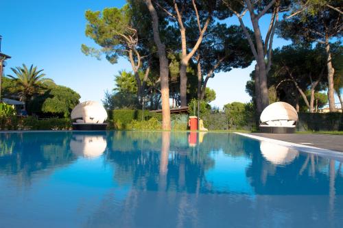 een zwembad van blauw water met bomen op de achtergrond bij Relais Villa Italia in Selcetta