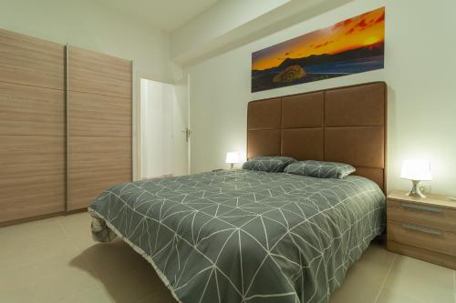 a bedroom with a bed and a painting on the wall at Apartamentos Bello Lanzarote in Arrecife