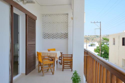 a room with a table and chairs on a balcony at Corali Hotel in Adamantas