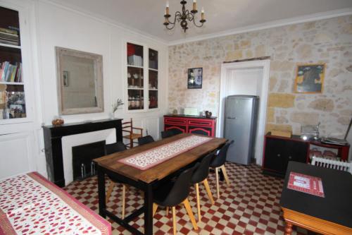 Un comedor con una mesa y un refrigerador. en Domaine L'Amourette, en Tizac-de-Curton