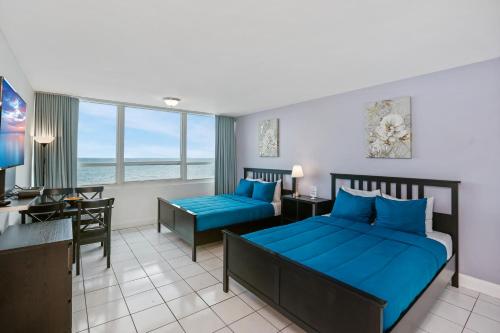 a hotel room with two beds and a desk at Miami Beach Apartments by MiaRentals in Miami Beach