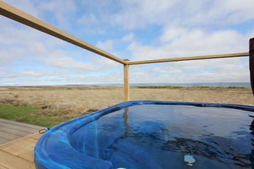 a hot tub on a deck with a view of a field at Blue View Cabin 5A With private hot tub in Reykholt