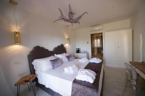 a bedroom with a bed and a dresser at Geco di Giada Art Suites - Adult Only in Porto Rotondo