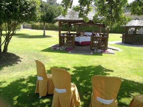 a gazebo with a table and chairs in the grass at Hostal La Casilla in Guitiriz