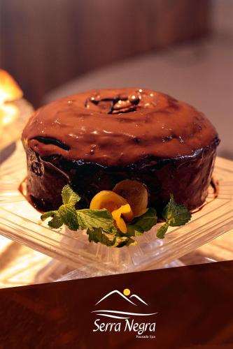 a chocolate cake on a plate on a table at Serra Negra Pousada Spa in Guarapari