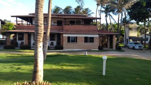 une maison avec un palmier en face dans l'établissement Pousada Via Lactea, à Canoa Quebrada