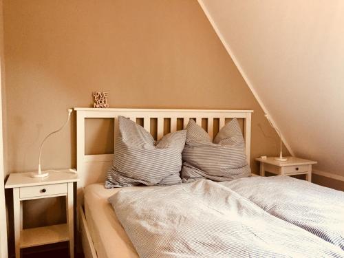 a bed with white sheets and pillows on it at LilO- mittendrin und ganz dicht bei in Itzehoe