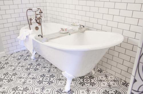 a white tub in a bathroom with a tile floor at The Rigdon House in Cambria