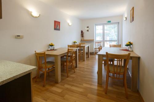 une salle à manger avec des tables et des chaises en bois dans l'établissement Pension Kraus, à Litomyšl