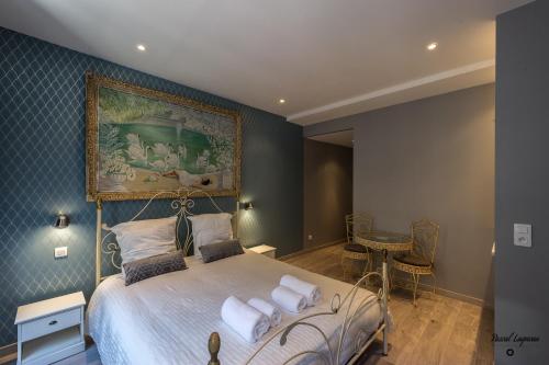 a bedroom with a bed with a painting on the wall at Cocoon amoureux de Beaune in Beaune