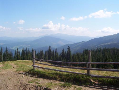 a wooden fence on top of a hill with mountains at Аня Рома in Lazeshchyna