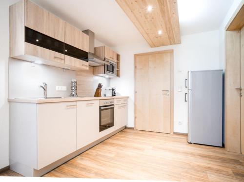a kitchen with white cabinets and a refrigerator at Ferienwohnung Hilber in Schmirn