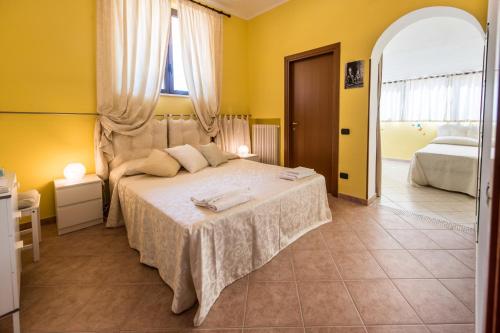 a bedroom with a large bed with yellow walls at B&B UN'ALTRA VITA in Ripa Teatina