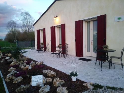 a patio with chairs and tables in front of a building at Agriturismo Honey Farm in Piazzola sul Brenta