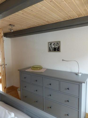 a dresser with a lamp on top of it in a bedroom at Alter Krämerladen von 1732 in Friedrichstadt
