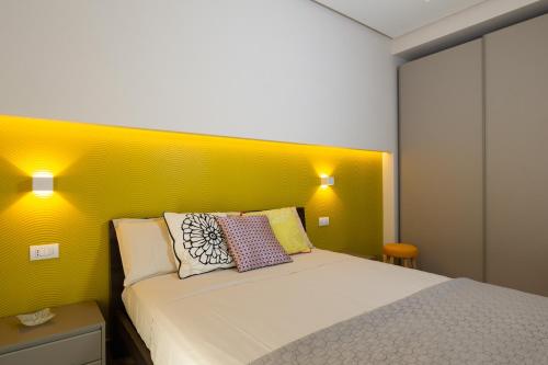 - une chambre avec un lit doté d'une tête de lit jaune dans l'établissement Casa Martina, à Castellammare di Stabia