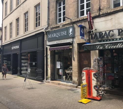 a street with shops on the side of a building at Cocoon amoureux de Beaune in Beaune