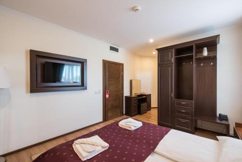 a bedroom with a bed and a tv on the wall at Pensiunea David in Târgu-Mureş