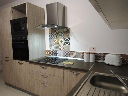 a kitchen with a sink and a stove at No8 @ Seabreeze Court in Mellieħa