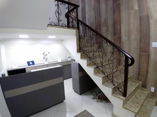 an office with a staircase with a counter and a stair case at Hotel Orleans in Petrópolis