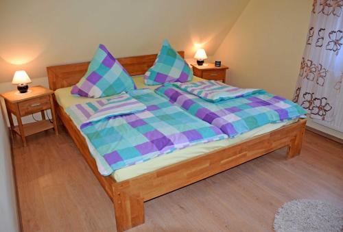グロヴェにあるFerienreethaus mit Kamin und Saunaのベッドルーム1室(紫と青の掛け布団付きのベッド1台付)