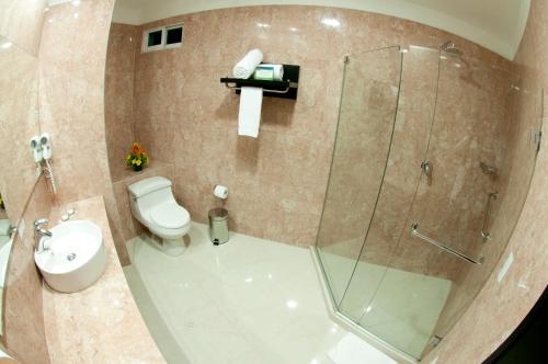 a bathroom with a toilet and a glass shower at Hotel Atlantic Lux in Cartagena de Indias