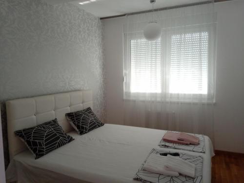 a bedroom with a white bed with a window at N&L in Banja Luka