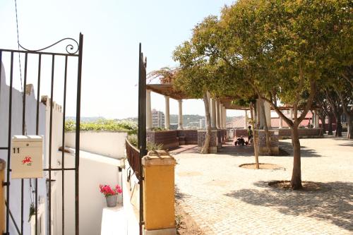 a gate to a patio with a tree and a building at Miradouro's Loft in Setúbal