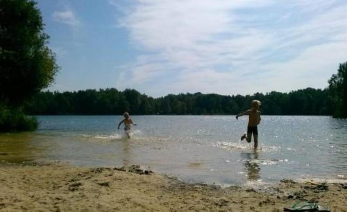 two children playing in the water on the beach at Holiday Home 'Beautifull Water' in Lanaken